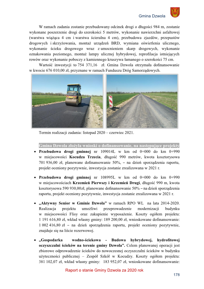 Droga wiejska w trakcie przebudowy, walec drogowy na świeżo położonym asfalcie, widok na prostą drogę gruntową z poboczem z kamiennego kruszywa, otoczenie pola uprawne i błękitne niebo.