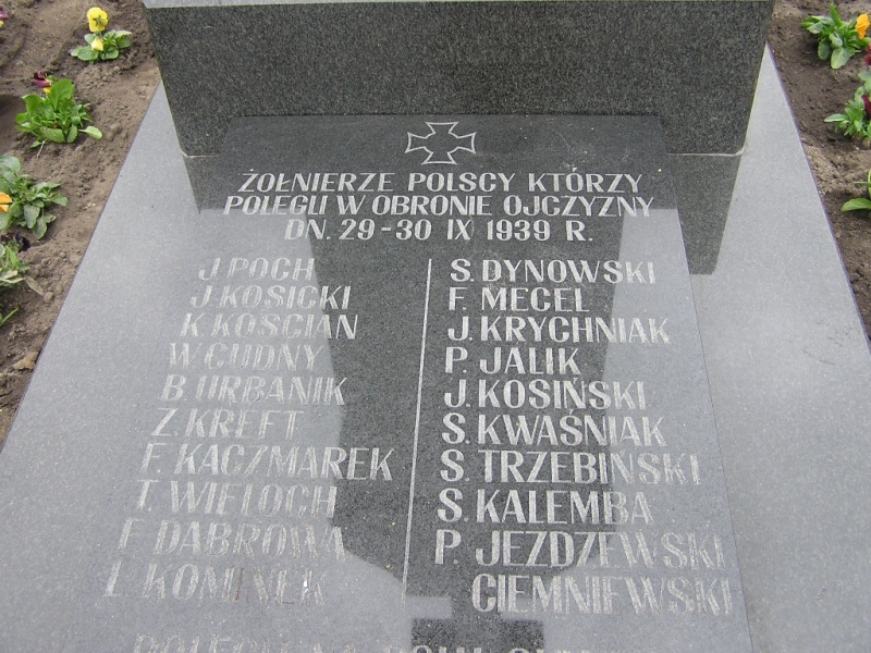 Tablica nagrobna z czarnego kamienia z białym napisem upamiętniającym polskich żołnierzy poległych we wrześniu 1939, z dwoma kolumnami nazwisk.