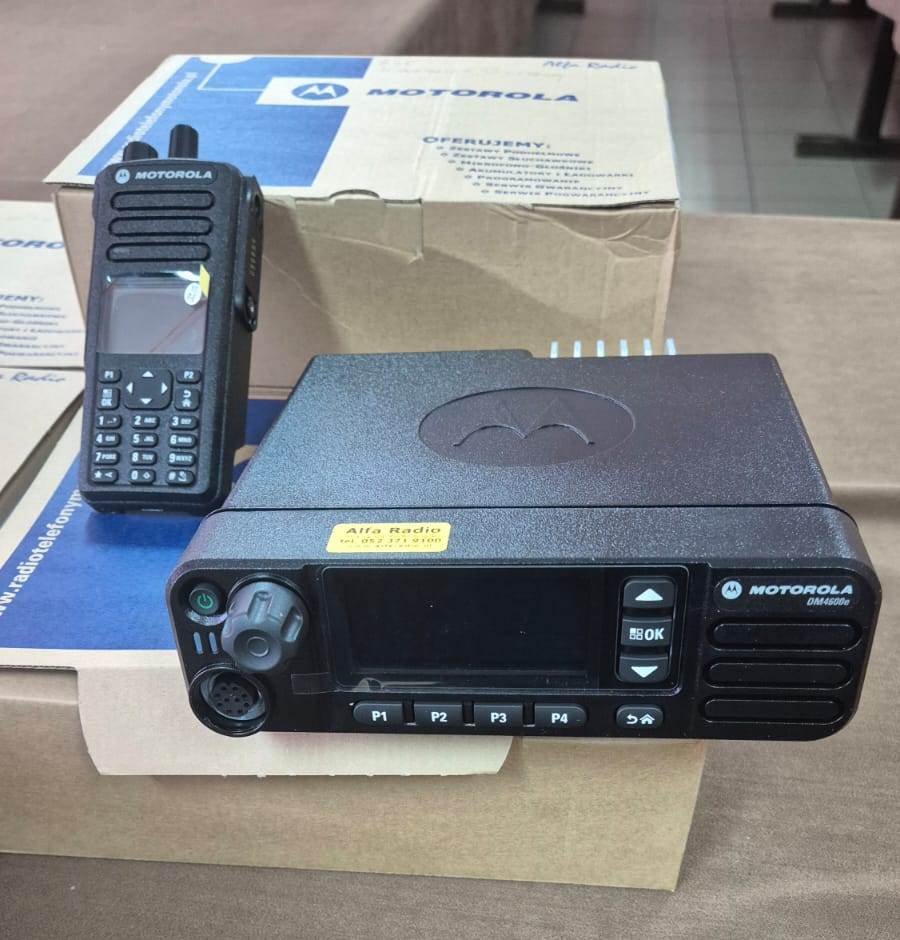 Czarny radiotelefon Motorola DM4600e z wyświetlaczem i przyciskami, czarny przenośny radiotelefon z klawiaturą, oba na kartonowych pudełkach z logo Motorola.