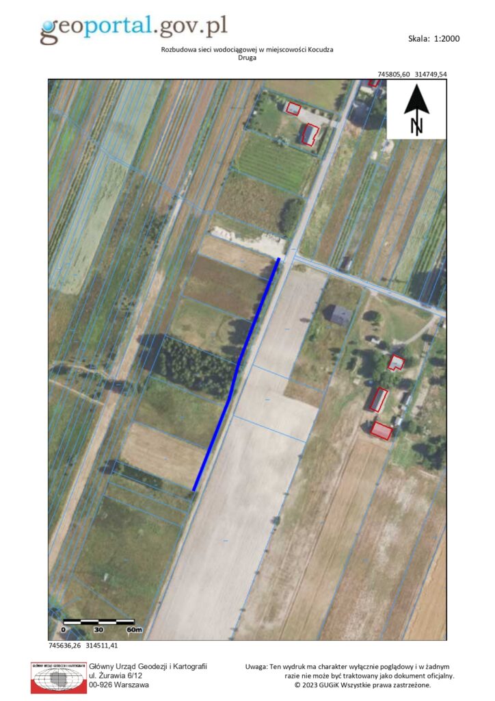 Mapa lotnicza z zaznaczonymi działkami wsi Kocudza Druga, obszar rolniczy z polami, drogami i kilkoma budynkami oznaczonymi czerwonym konturem, niebieska linia wzdłuż drogi.